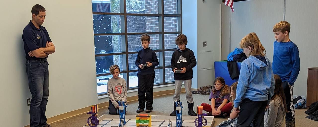 A group of boys test out small robots during an afterschool program.